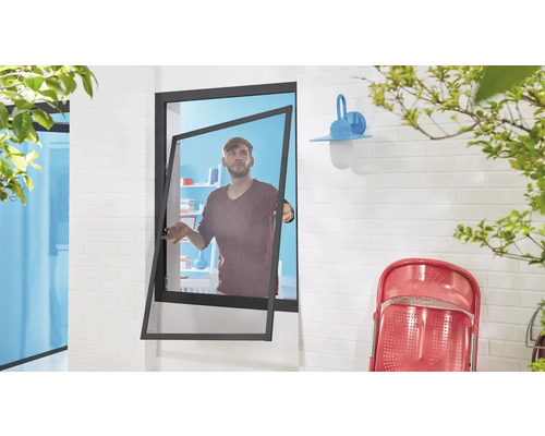 Geöffnetes Fenster mit Insektenschutzgitter zeigt einen Mann im Innenraum