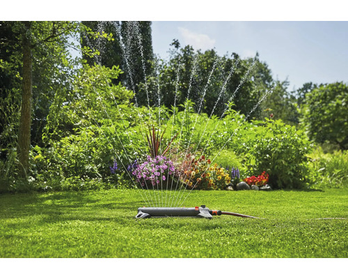 Rasensprenger im Garten bewässert Rasenfläche