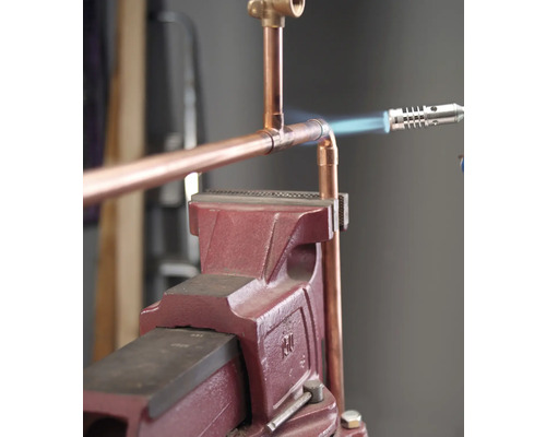 Kupferrohr wird mit einer Lötlampe und einer Werkbank verbunden