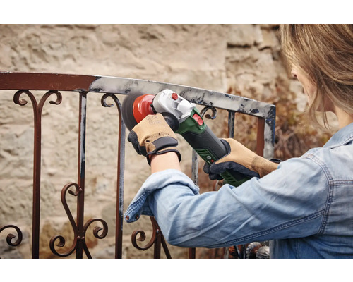 Frau schleift Metallgeländer mit Winkelschleifer