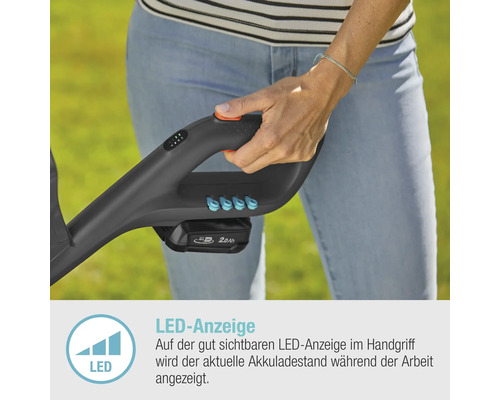 Nahaufnahme einer Person, die einen Rasentrimmer mit LED-Anzeige zur Akkulaufzeit hält