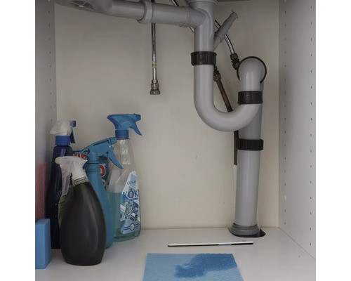Siphon unter einem Waschbecken mit Reinigungsutensilien