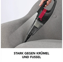 Akkusauger im Einsatz auf einem grauen Sessel