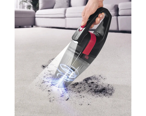 Ein Handstaubsauger wird auf einem Teppich verwendet, um Schmutz zu entfernen.