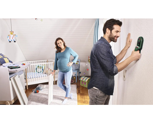 "Mann benutzt Ortungsgerät an Wand