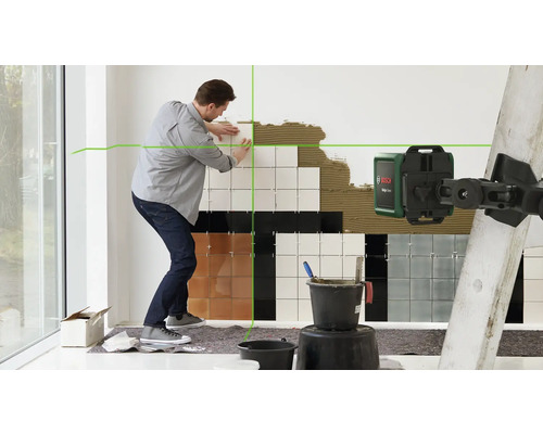 Mann verlegt Fliesen mit einem Kreuzlinienlaser von Bosch