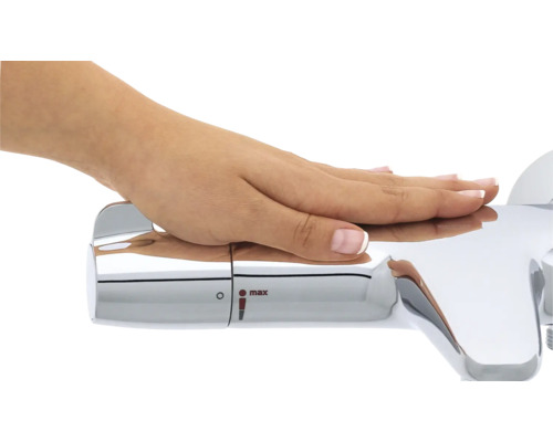 Nahaufnahme einer Hand, die einen verchromten Wasserhahn mit Temperaturregler bedient