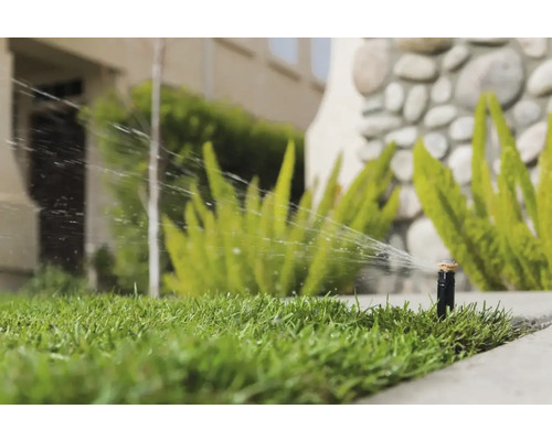 Rasensprenger bewässert Rasenfläche im Garten