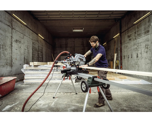 Mann arbeitet mit einer Metabo Kapp- und Gehrungssäge in einer Werkstatt, um Holz zu schneiden.