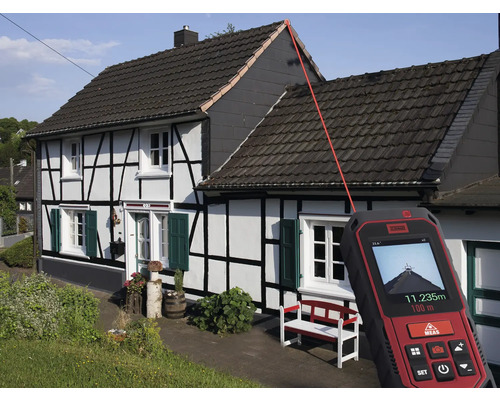 Ein Laser-Entfernungsmesser misst die Länge eines Hausdaches.