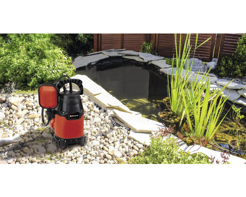 Tauchpumpe neben einem Gartenteich mit Steinen und Pflanzen