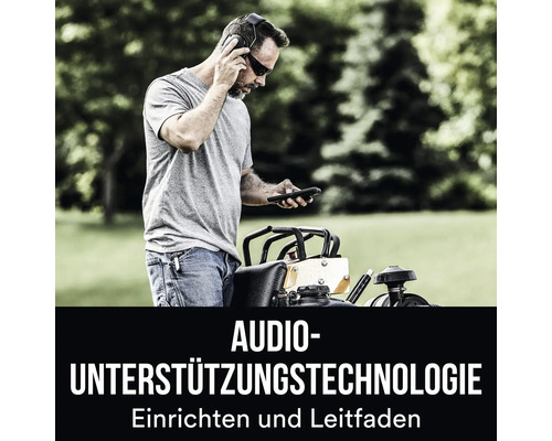 Mann mit Gehörschutz und Smartphone neben einer Rüttelplatte