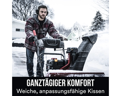 Eine Person benutzt eine Schneefräse auf einer verschneiten Auffahrt.