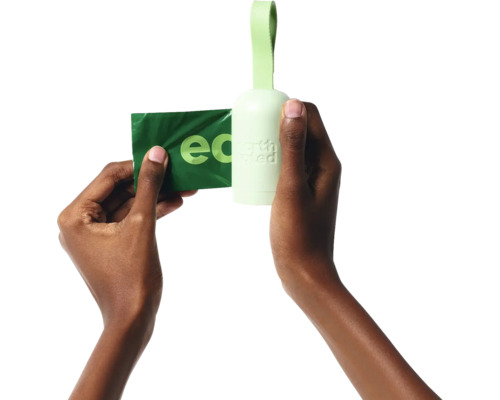 Hände halten einen Hundebeutelspender und eine Hundekottüte