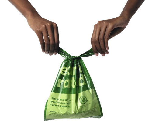 Grüne Müllbeutel aus Recyclingkunststoff in der Hand