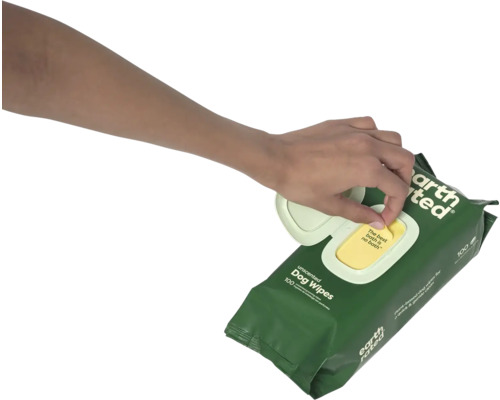 Eine Hand zieht ein Feuchttuch aus einer Packung Hundefeuchttücher.