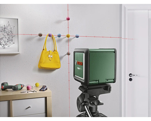 Raumansicht mit Kreuzlinienlaser auf Stativ zum Ausrichten von Objekten an einer Wand