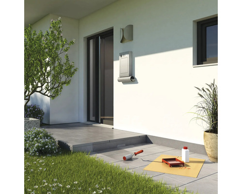 Szene mit Briefkasten, Pflastersteinen und Malerzubehör vor einem Haus