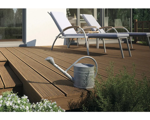 Terrasse mit Holzfliesen und Gartenmöbeln sowie einer Gießkanne