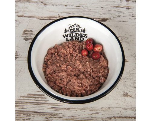 Hundenahrung in einer Schüssel mit Wildes Land Logo und Preiselbeeren