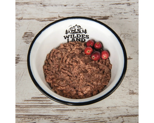 Hundenassfutter in einer Schüssel mit Preiselbeeren und Wildes Land Logo.
