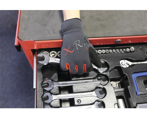 Ein Werkzeugwagen mit Schraubenschlüsseln und eine Hand mit einem Arbeitshandschuh