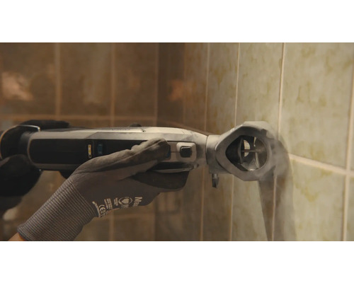 Eine Person verwendet ein oszillierendes Elektrowerkzeug an einer gefliesten Wand.