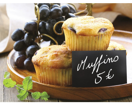 Zwei Muffins mit Preisschild und Trauben auf einem Holztablett