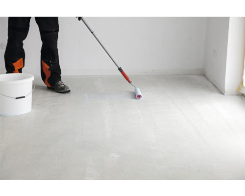 Person rollt Bodenfarbe auf einen Betonboden mit einer Farbrolle.