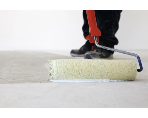 Person rollt Bodenfarbe mit Farbroller auf Boden