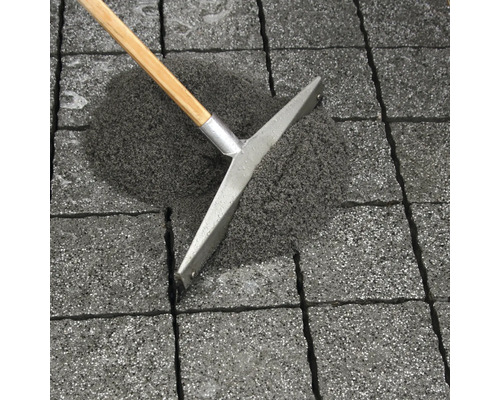 Verlegung von Pflastersteinen mit Fugensand und Fächerbesen