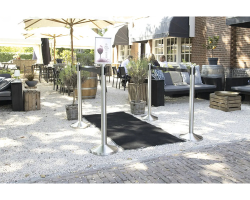 Außenbereich mit Absperrpfosten und schwarzem Teppich auf Kies