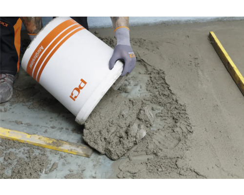 Estrich wird aus einem Eimer von PCI gegossen.