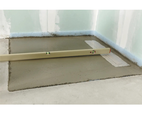 Ausgleichsmasse wird mit einer Wasserwaage aufgetragen