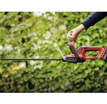 Eine Person bedient eine Akku-Heckenschere von Einhell zum Schneiden von Hecken.