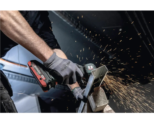 Mann schleift Metall mit einem Metabo Winkelschleifer, Funken fliegen.