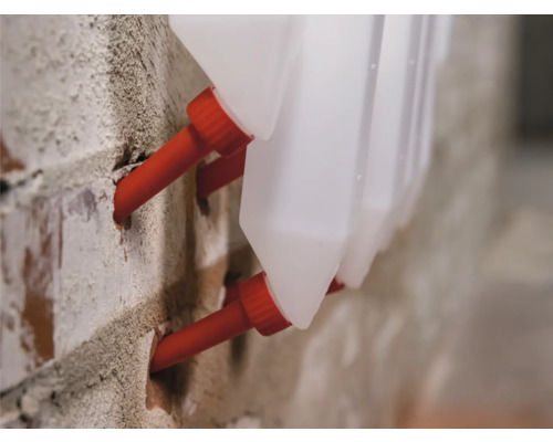 Detailaufnahme von Flüssigkeitsbehältern mit Wanddurchführung in einem Mauerwerk.