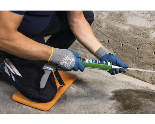 Handwerker verwendet eine Kartuschenpistole auf einer Baustelle.