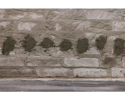 Backsteinmauer mit Mörtelflecken