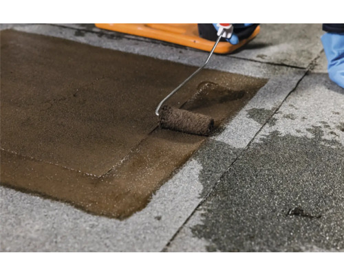 Auftragen einer Beschichtung auf eine Dachpappe mit einer Farbwalze.