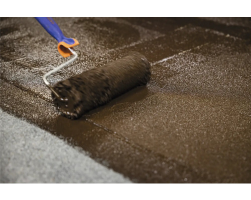 Farbroller trägt Beschichtung auf Boden auf