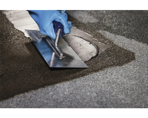 Verarbeiten von Fugenmasse mit einem Spachtel auf einer Oberfläche