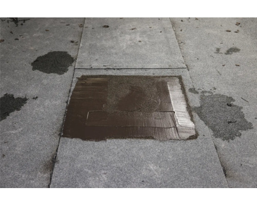 Flachdachreparatur mit Bitumenflicken auf Dachpappe