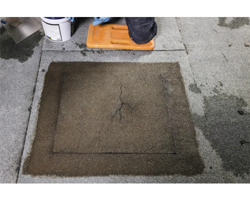 Szene der Reparatur eines Daches mit Bitumenreparaturmasse, Eimer und Werkzeugen