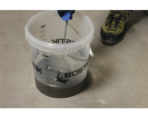 Mischen von Bostik Estrich in einem Eimer