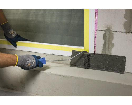 Abdichtung mit Farbroller an Mauerwerk