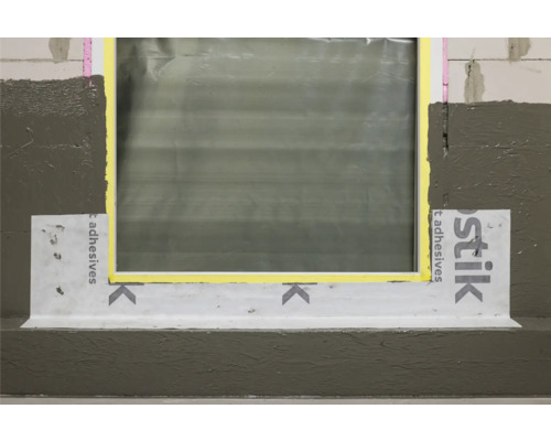 Fensteranschluss mit Dichtband und Dichtmasse an einer Fassade.