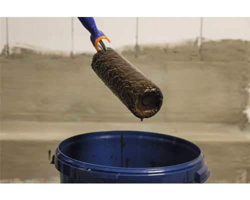 Farbroller mit Farbe über einem Farbeimer