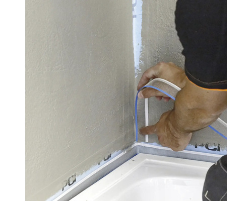 Verlegung eines Dichtbandes in einer Ecke im Badezimmer