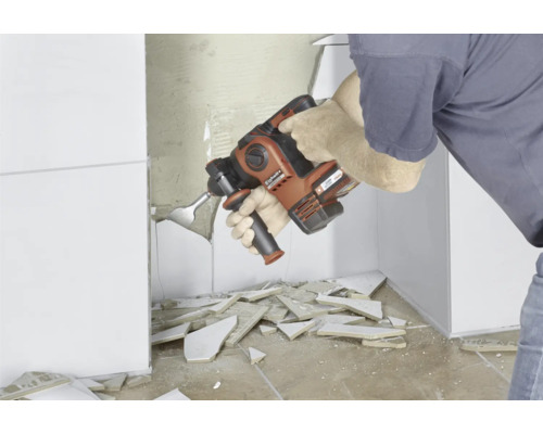 Ein Mann entfernt Fliesen mit einem Abbruchhammer von Einhell